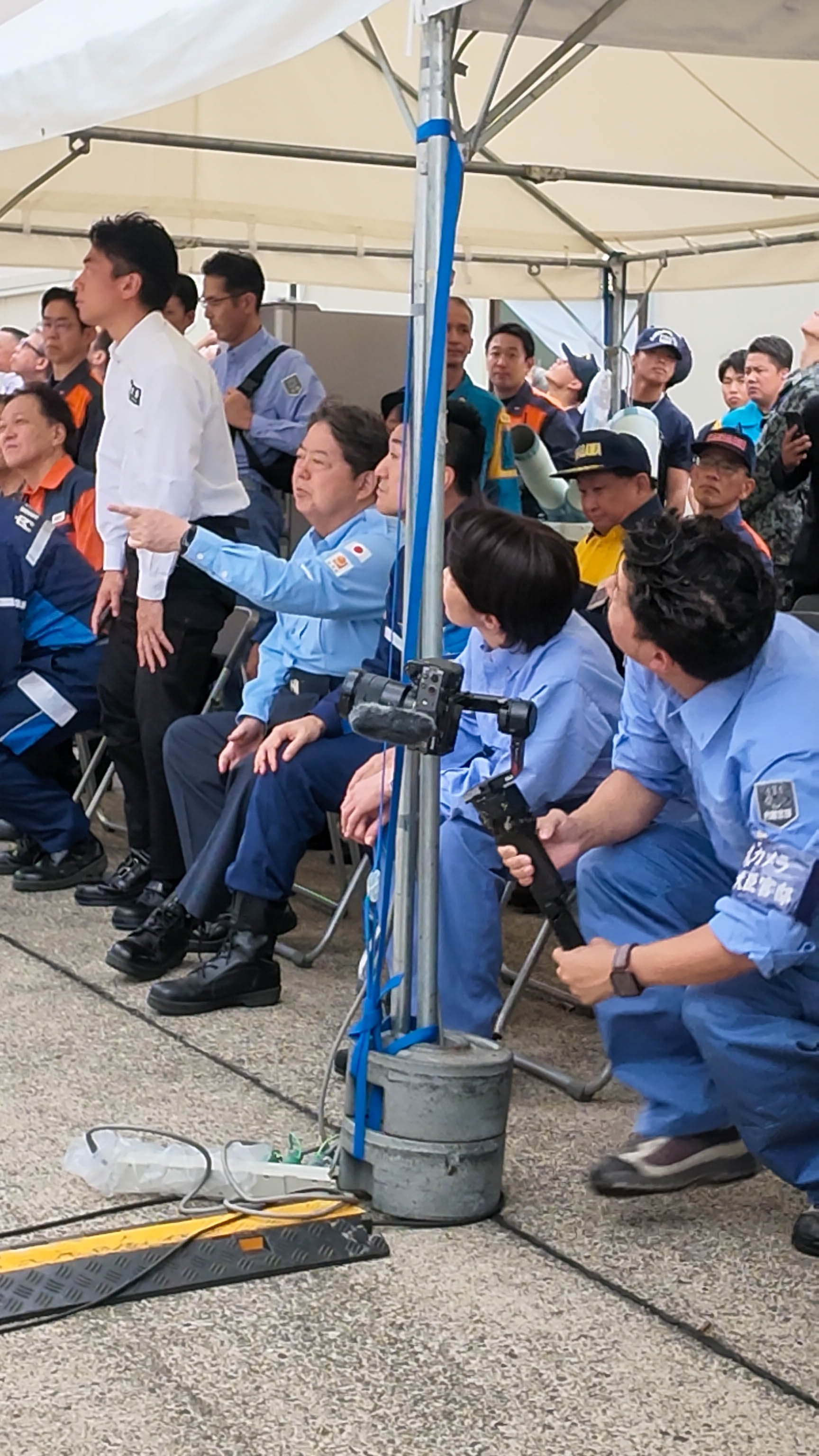 テントでデモを見守る高市総理ら政府調査団